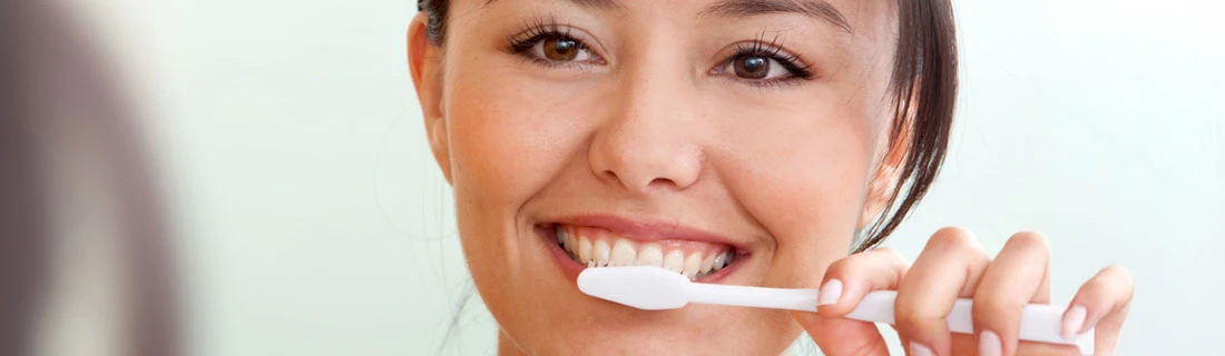 Woman Brushing Her Teeth Smiling