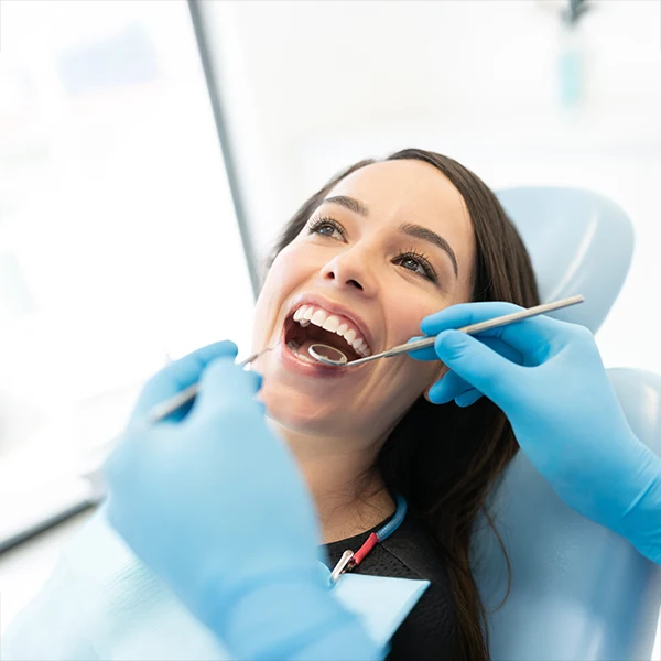 Dentist-Giving-A-Woman-A-Dental-Checkup-600x600-Moto.webp