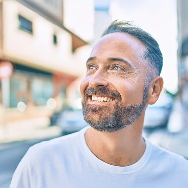 Dentist-Man-With-Beard-Smiling-Outside-600x600-Moto.webp