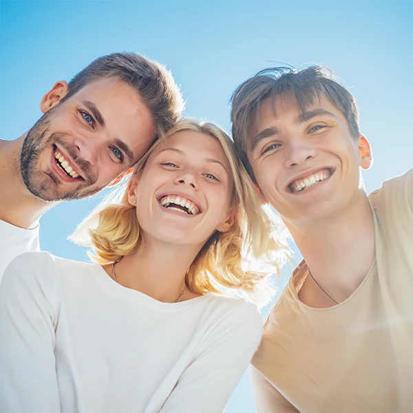 Dentist-Three-Friends-Smiling-Outside-600x600-Moto.webp