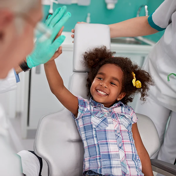 Dentist-With-Lovely-Kid-In-Dental-Chair-600x600-Moto.webp