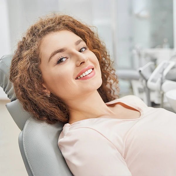 Dentist-Woman-In-Dental-Chair-For-A-Cleaning-600x600-Moto.webp